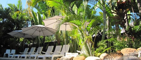 Een buitenzwembad, parasols voor strand/zwembad