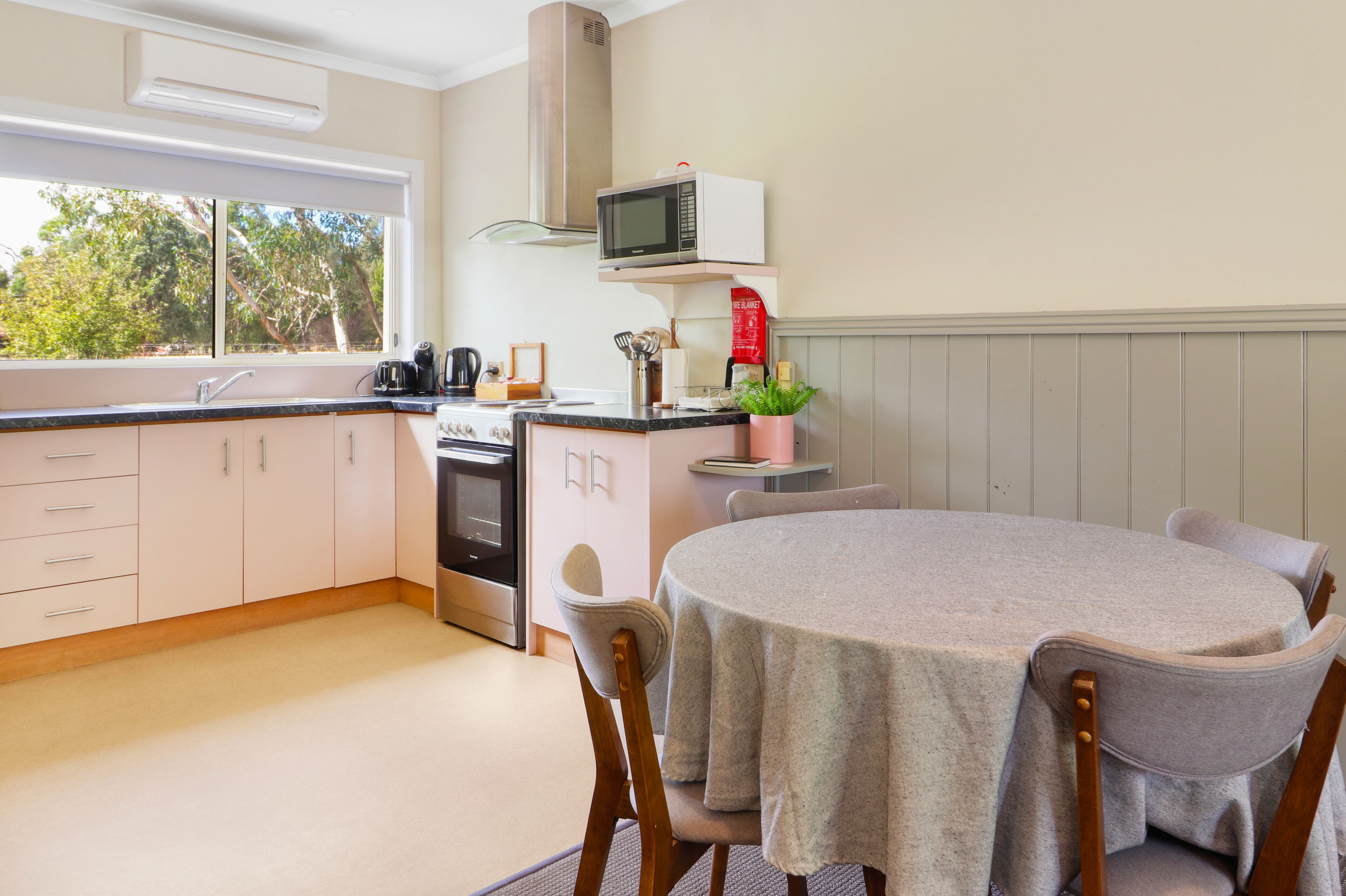 Una cocina moderna con comedor, que cuenta con un microondas, estufa y armarios.