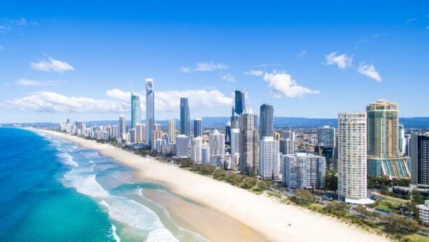 A coastal cityscape with high-rise buildings along a sandy beach. - Tropicana Motel (Mermaid Beach)