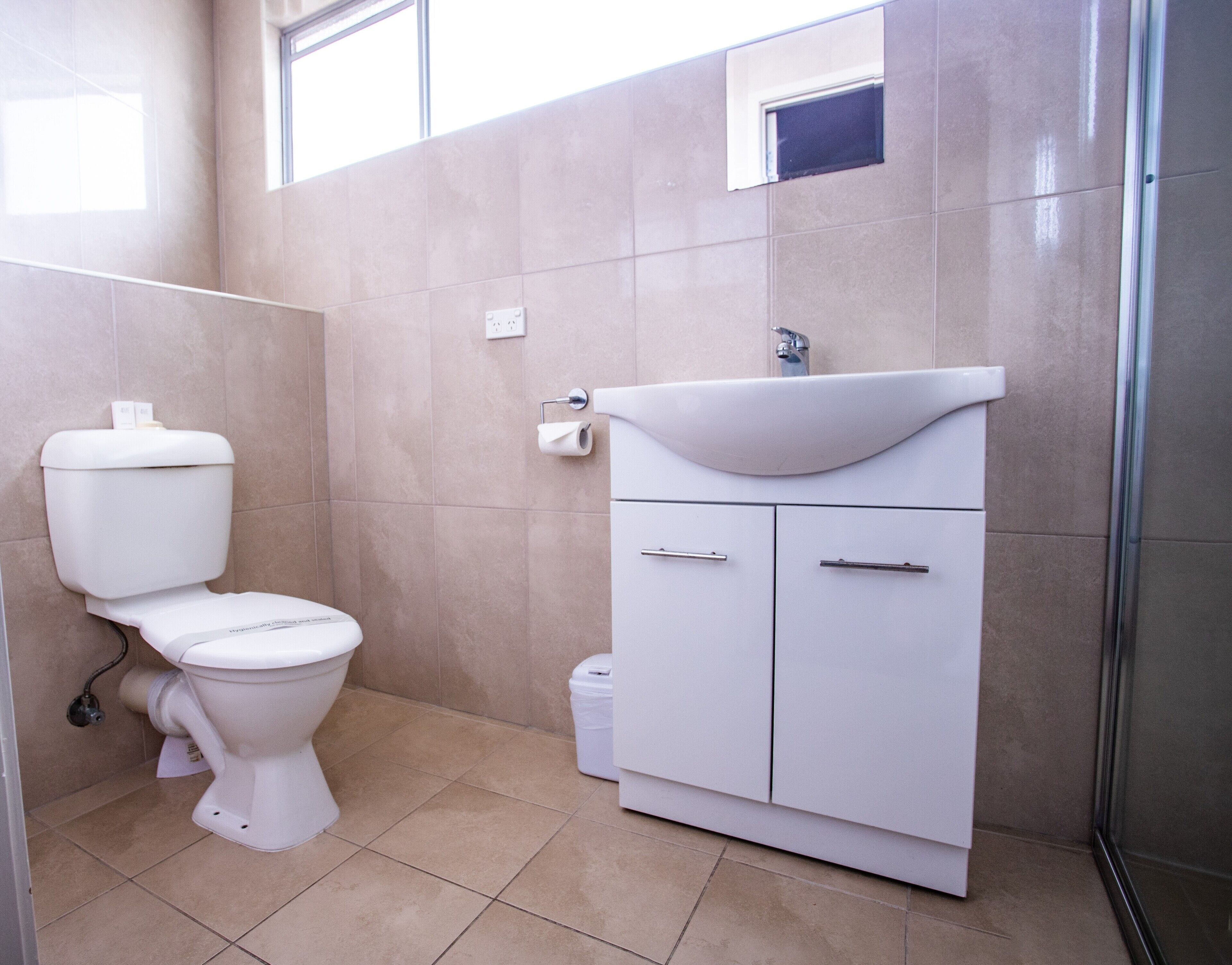 Un baño con inodoro, lavabo y armario.