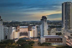 A hotel complex with multiple high-rise buildings, a central building with a sign, and a view of the cityscape in the background. - Four Points by Sheraton Johor Bahru (Masai)