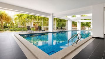 Una piscina techada, sillones reclinables de piscina