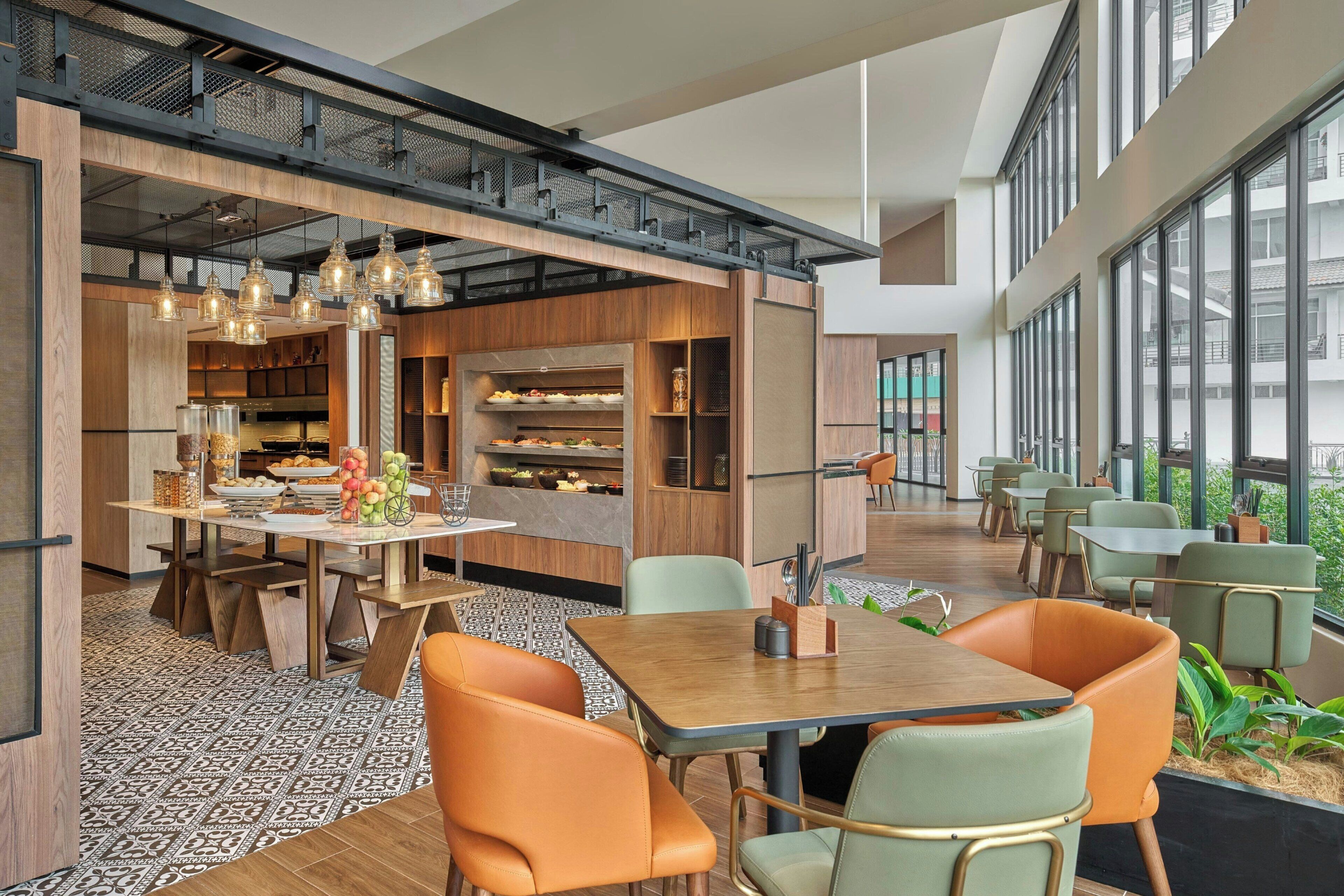 A modern restaurant with a high ceiling, exposed beams, and large windows.