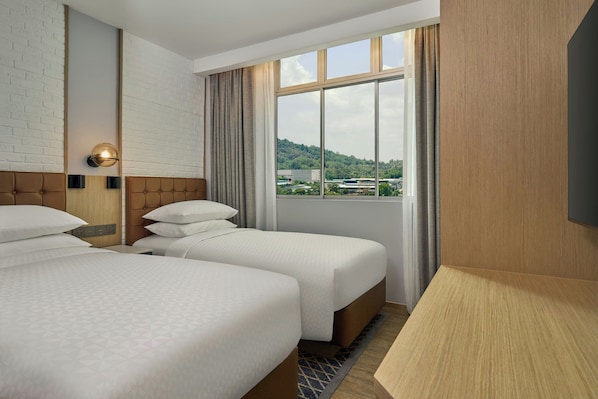 Habitación de hotel con dos camas, un ventanal con vistas, un televisor de pantalla plana y una lámpara de pared.
