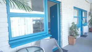 A building with a white brick exterior and blue-framed windows. - Marlin Motel (Biggera Waters)