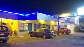 A motel named 'Marlin' with a parking lot and two cars parked in front. - Marlin Motel (Biggera Waters)