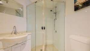 A modern bathroom with a glass-enclosed shower, a sink, and a toilet. - Marlin Motel (Biggera Waters)