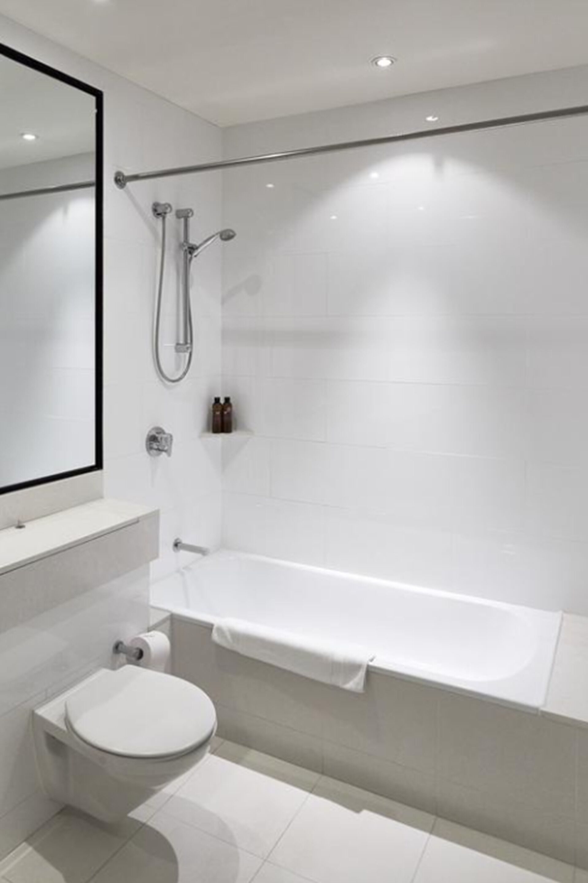 A modern bathroom with a toilet, a shower, and a bathtub.