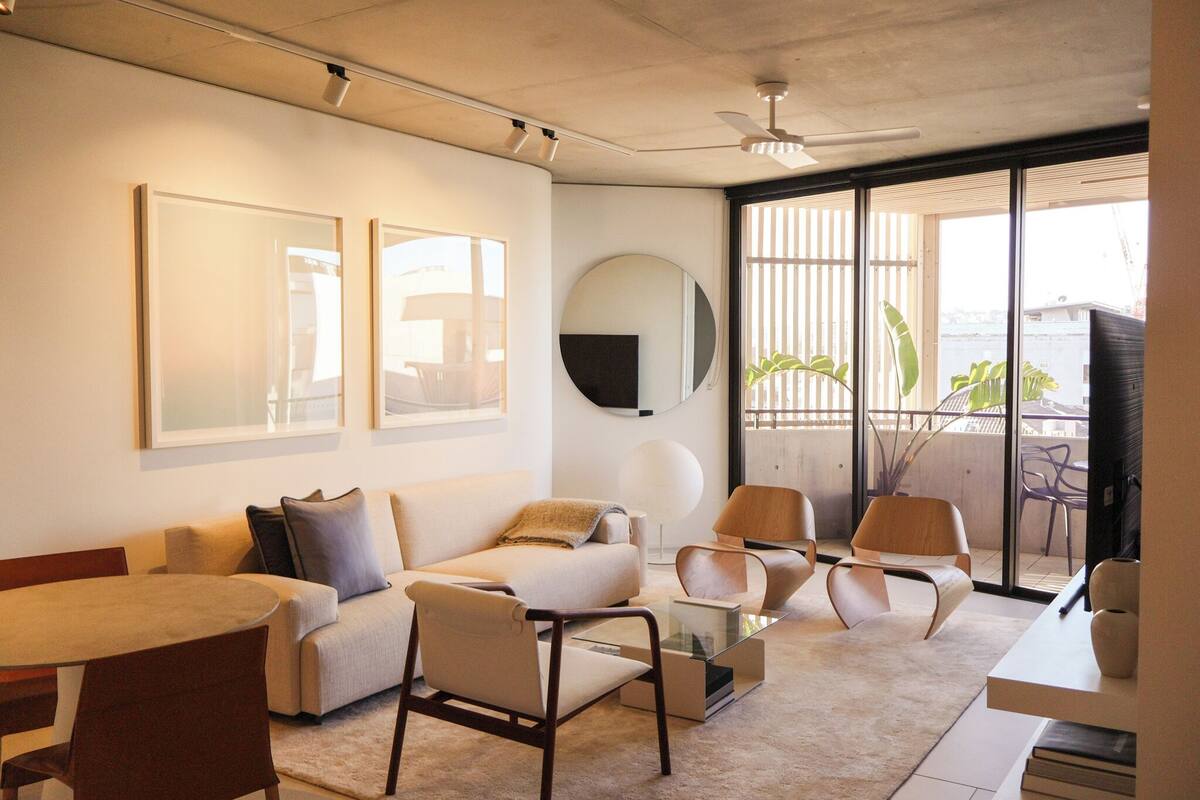 A modern living room with a sofa, chairs, a coffee table, and artwork on the walls.