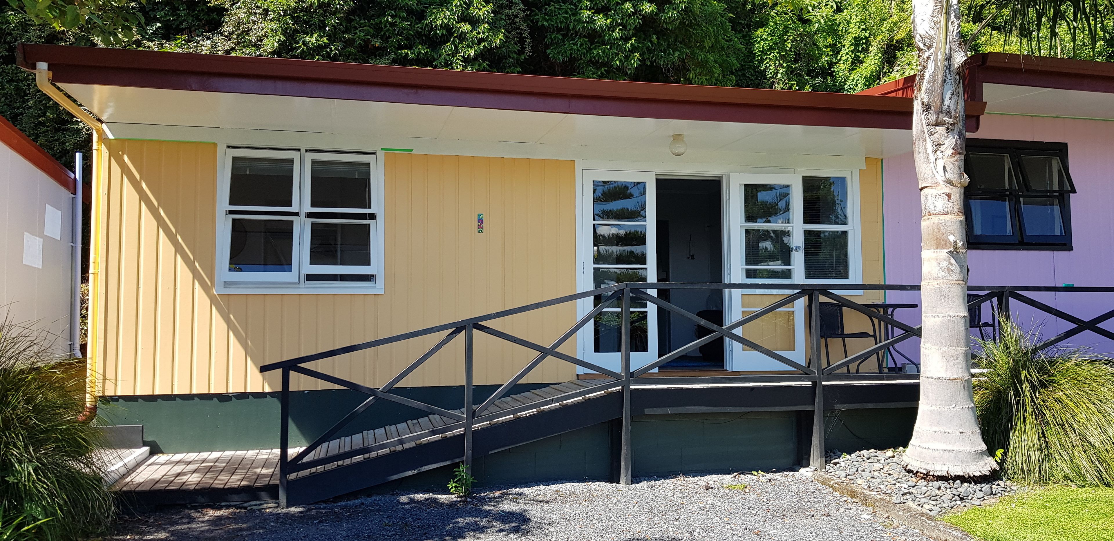 A small, single-story building with a wooden exterior, a ramp leading to the entrance, and a small porch area.