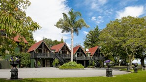 A building with multiple balconies and a central palm tree.
