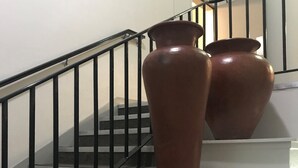 A staircase with two large terracotta vases placed on the steps.
