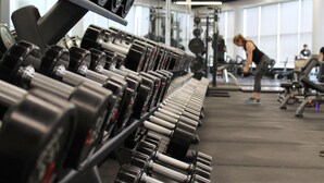Un gimnasio con filas de mancuernas y máquinas de pesas.