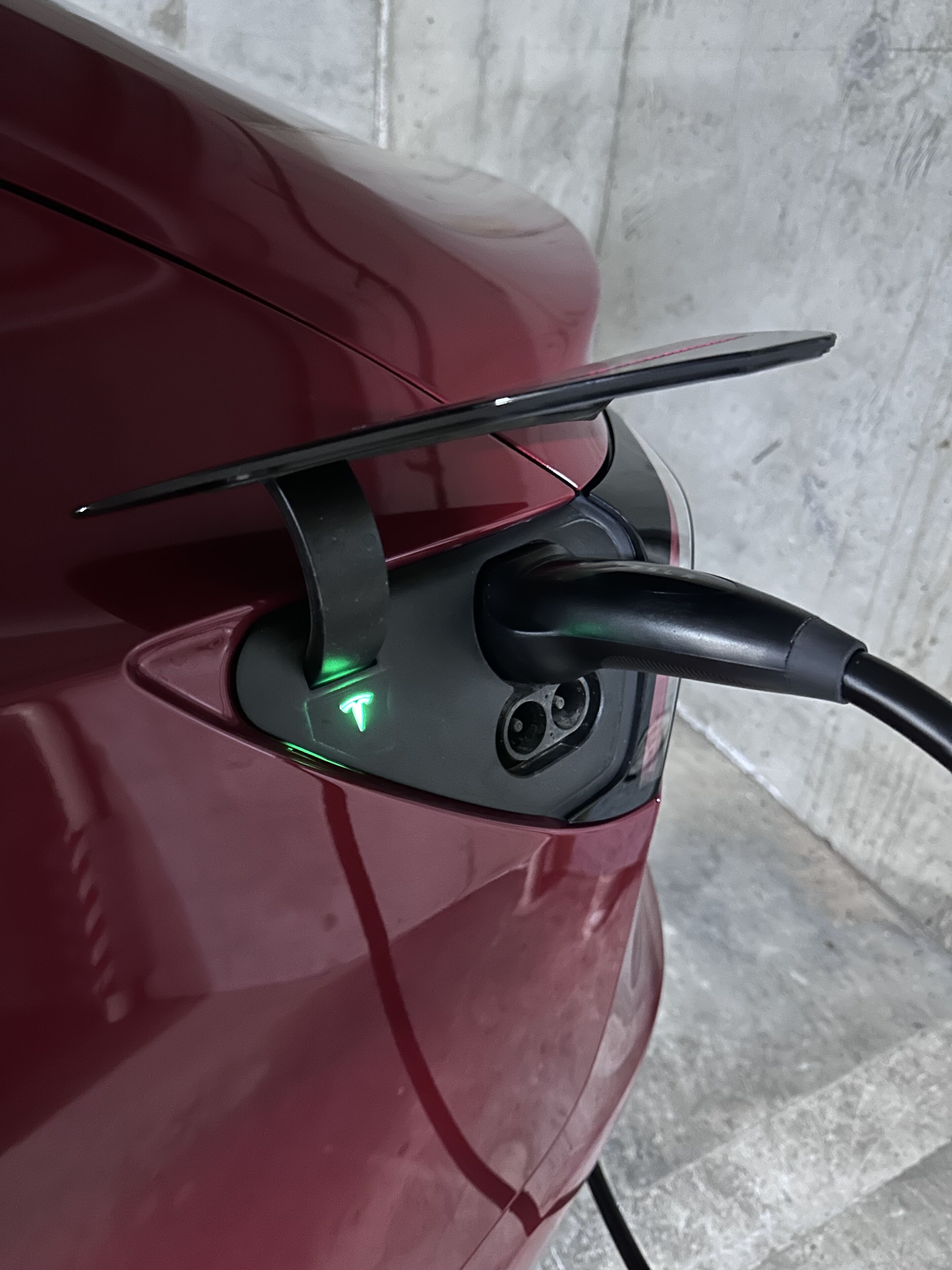 A red vehicle with a charging station attached to its rear.