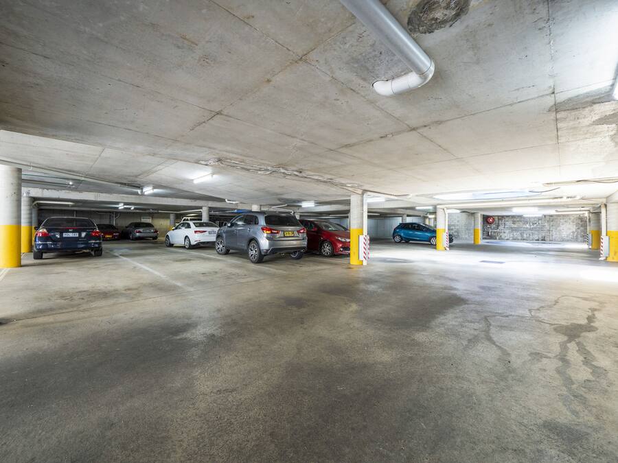 Een meerlaagse ondergrondse parkeergarage met verschillende geparkeerde auto's.