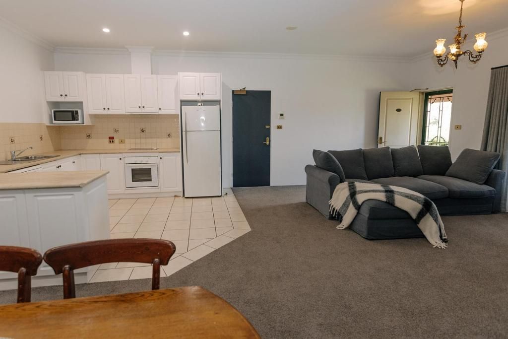 A compact living space with a kitchenette, a sofa, and a dining area.