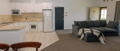A compact living space with a kitchenette, a sofa, and a dining area.