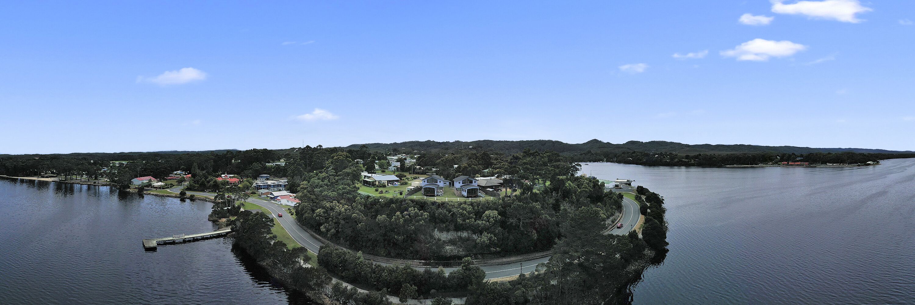 An aerial view of a small island with a few buildings, surrounded by water.
