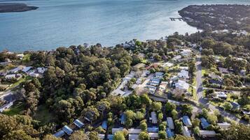 An aerial view of a residential area with houses, roads, and a large body of water.