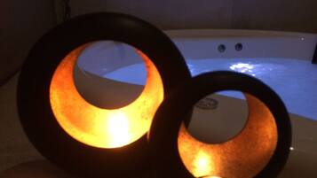 Two illuminated rings on a table with a hot tub in the background.