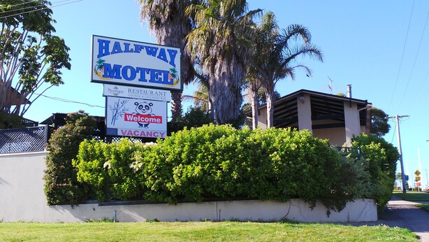 A sign for Halfway Motel with a welcome message and a vacancy notice.