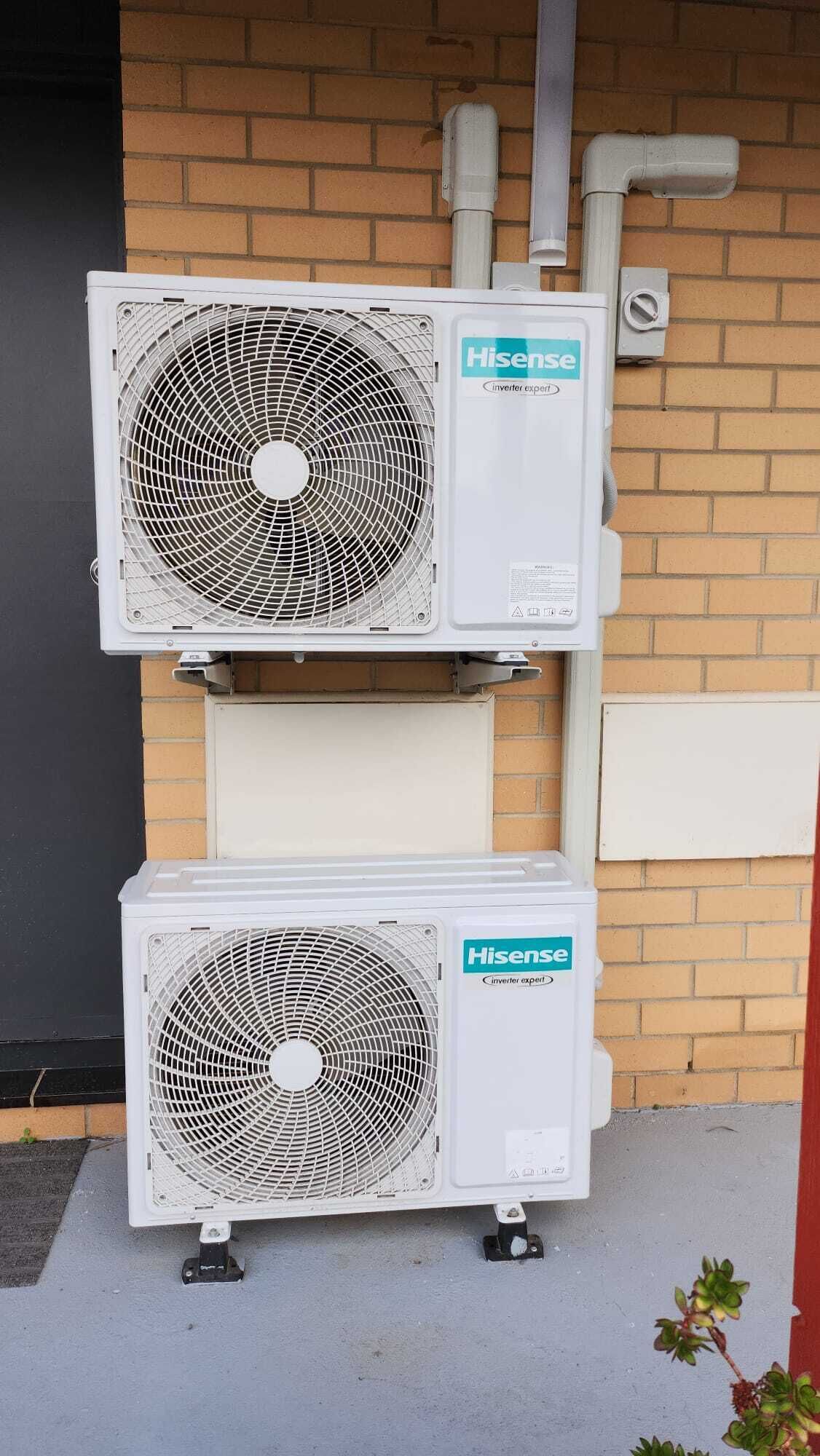 Dois aparelhos de ar condicionado Hisense inverter, modelo Expert, fixados em parede de tijolos.