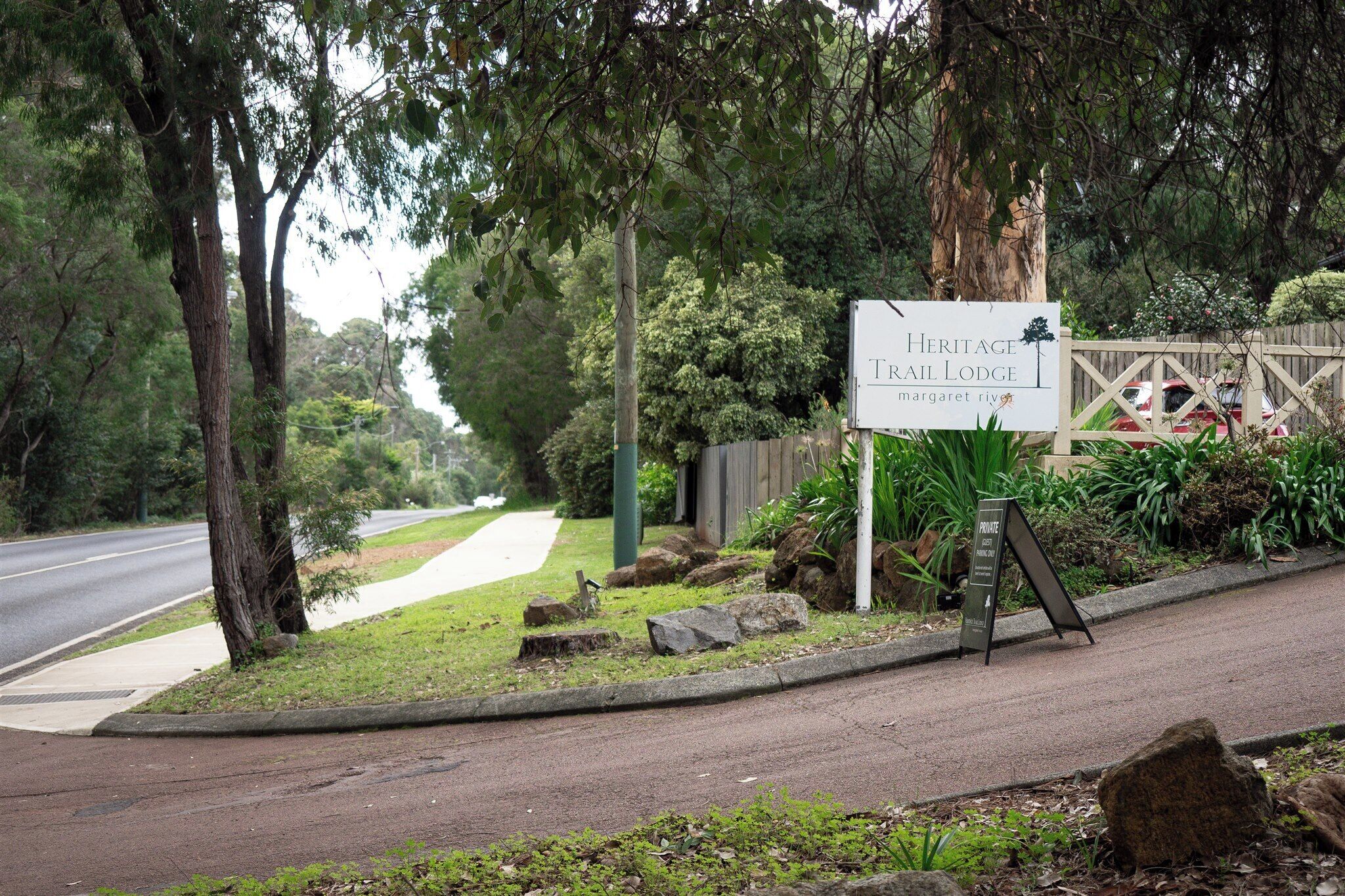 Señal de Heritage Trail Lodge mostrando una vista de la carretera y árboles.