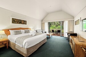 Una habitación de hotel con una cama grande, un escritorio y vistas al exterior.