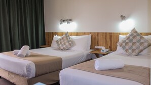 A hotel room with two beds, each with a wooden headboard, white bedding, and a brown throw blanket. There are two nightstands with lamps and a telephone. - Motel Riverina (Leeton)