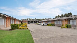 A motel with a central courtyard, two-story buildings, and a parking area.