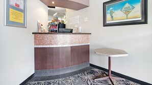 A reception area with a tiled counter, a small table, and framed artwork on the walls.