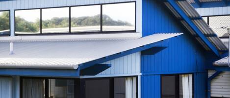 Un edificio de dos pisos con ventanas grandes y techo plano.