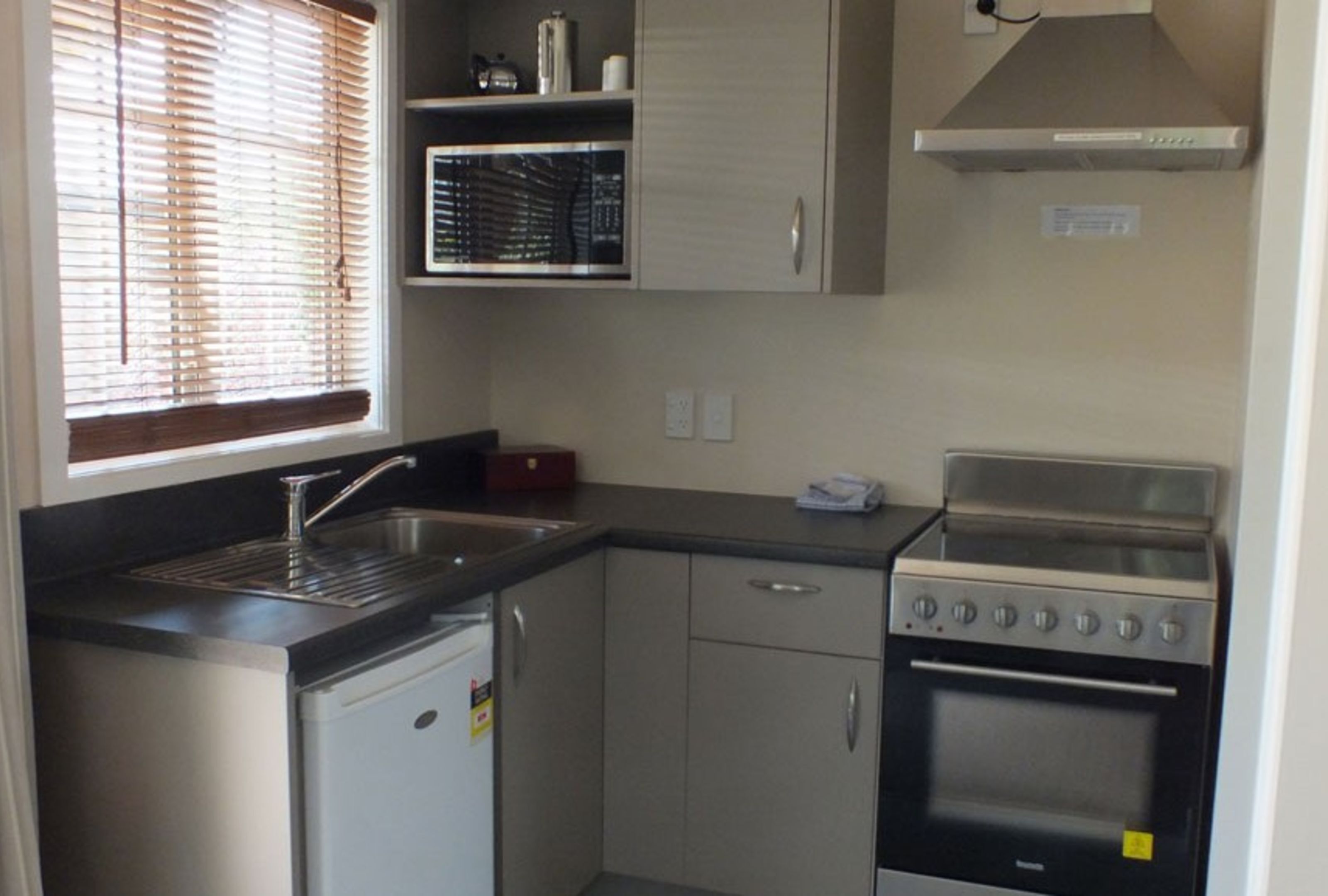Una cocina compacta con lavavajillas, horno y cocina.