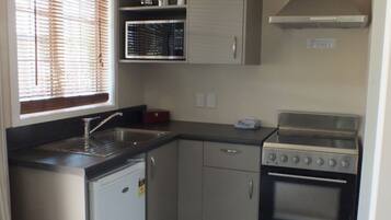 Una cocina compacta con lavavajillas, horno y cocina.
