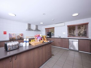 Una cocina moderna con tostadora integrada, cafetera y lavavajillas.