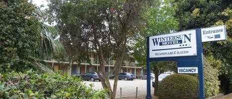 Une enseigne indiquant le « Wintersun Motel », avec une annonce signalant qu’il y a des chambres disponibles et une flèche indiquant l’entrée.