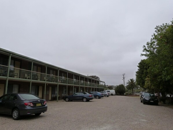 A motel with a two-story structure, multiple parking spaces, and a gravel driveway. - Wintersun Motel (Victor Harbor)