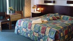 Una habitación de hotel con cama, escritorio y silla.