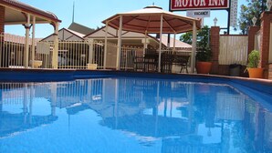 Una piscina con una zona de estar cubierta y un cartel que indica que no hay habitaciones disponibles.