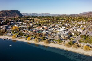 A coastal town with a marina, buildings, and mountains in the background. - Aspiring Lodge Motel (Wanaka)