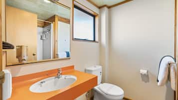 Un baño con lavamanos, inodoro y ventana.