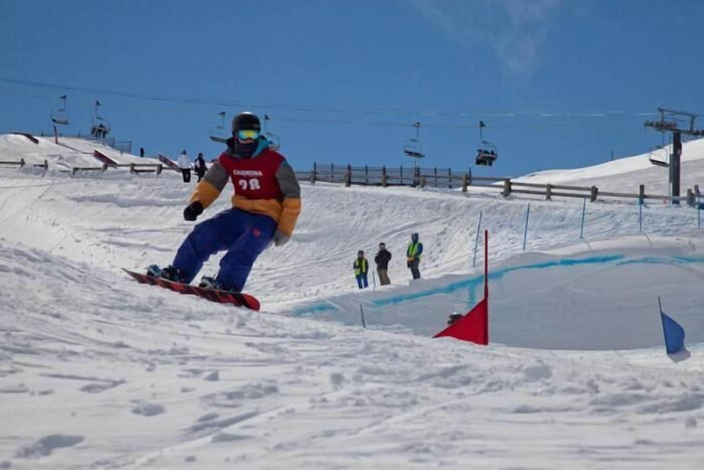 A snowboarder performing a jump at a ski resort.