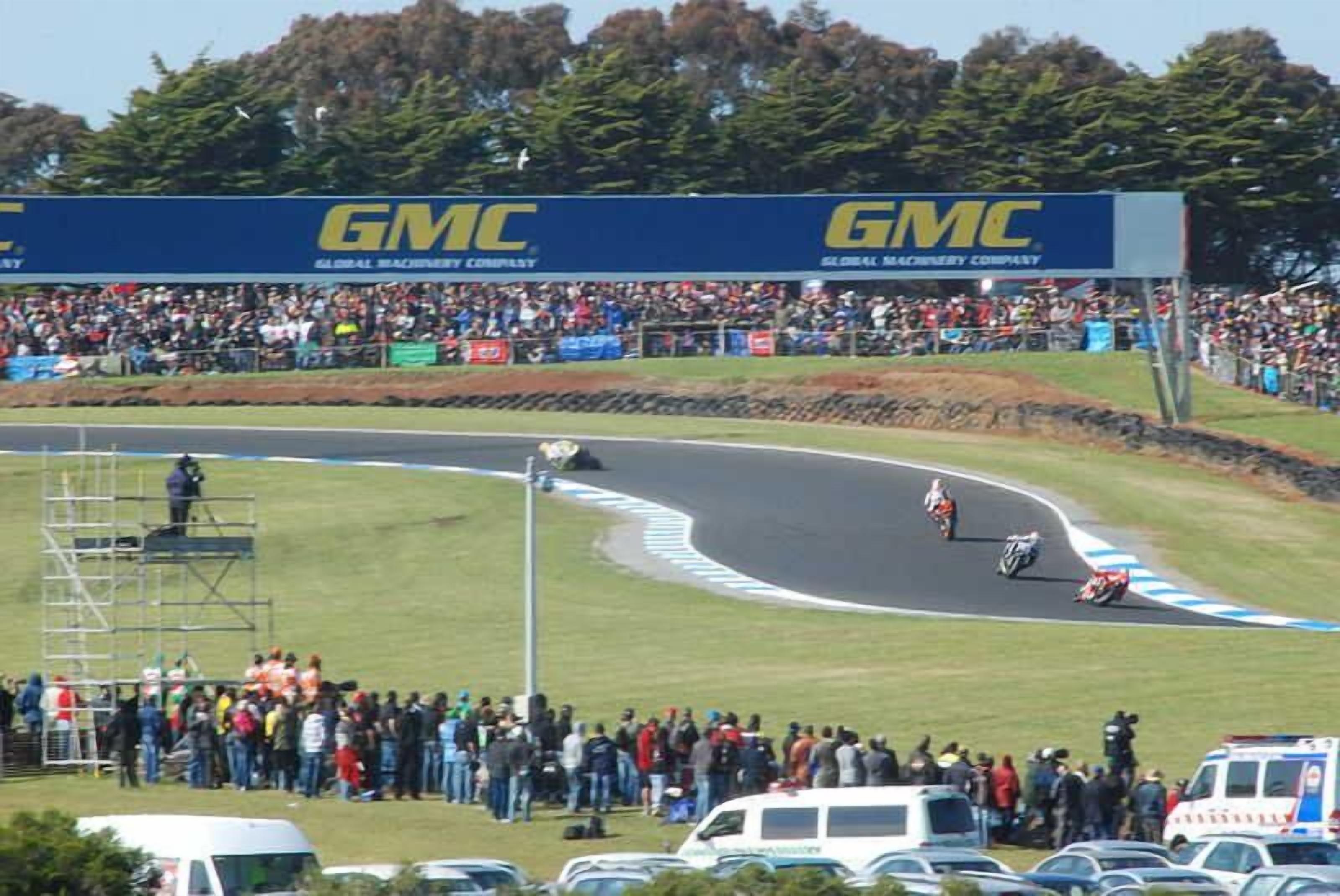 A race track with a crowd of spectators and a GMC advertisement.