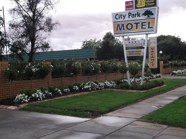 Une enseigne de motel indiquant un établissement classé trois étoiles, ainsi qu’une pancarte de bienvenue.