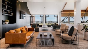 Una sala de estar moderna con sofás de cuero, una mesa de centro y un ventanal con vistas al exterior.