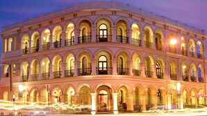 Un edificio de varios pisos con estilo arquitectónico clásico, que presenta numerosos balcones y ventanas de arco.
