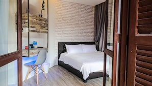 Een slaapkamer met een bed, een bureau en een stoel.