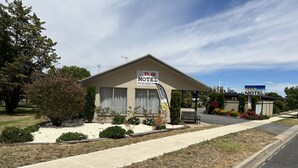 A motel with a signboard, a small garden, and a clear sky. - Kaniva Midway Motel (Kaniva)
