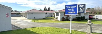 Un motel con un cartel de 'No Vacantes', una señal de límite de velocidad y un letrero que indica 50+ canales Sky.