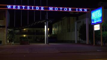 The exterior of the Westside Motor Inn, featuring a prominent neon sign and a covered entrance area.